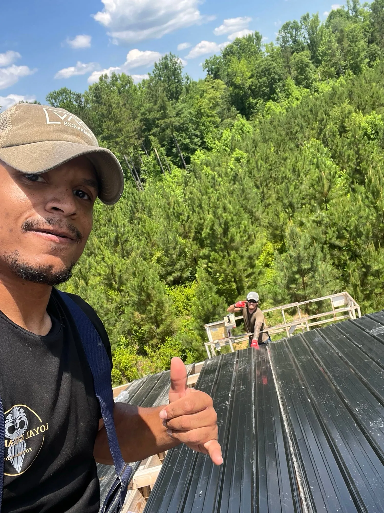 A thumbs up from the rooftop, woods stretching out behind