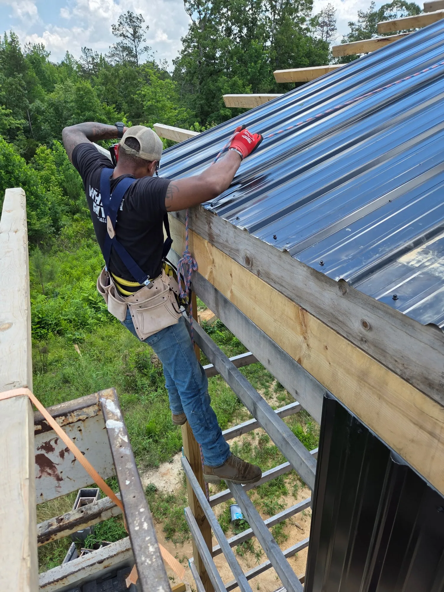 Fastening metal roofing from the top of a ladder