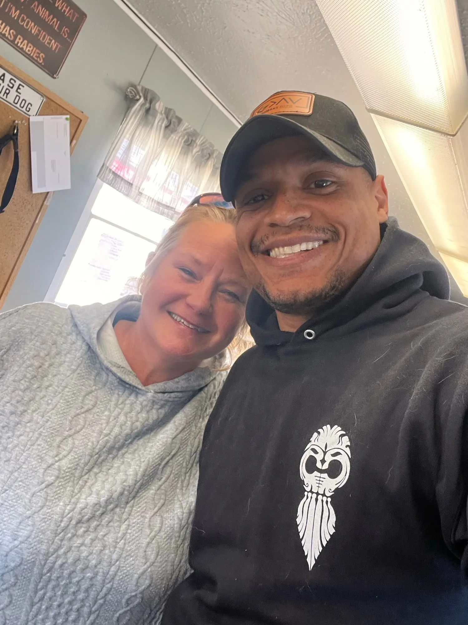 Josh smiling beside a friend in a sunny kitchen
