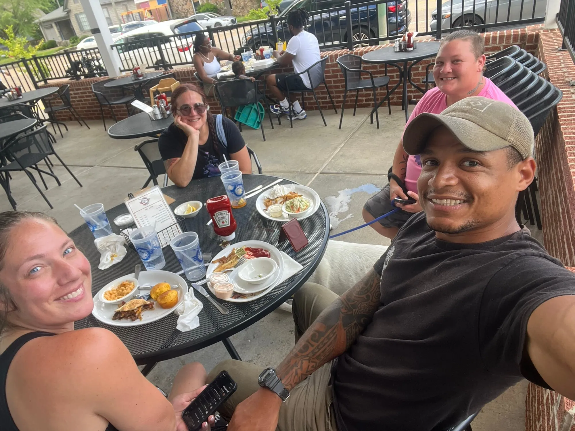 Josh sharing a meal outdoors with friends around a crowded table