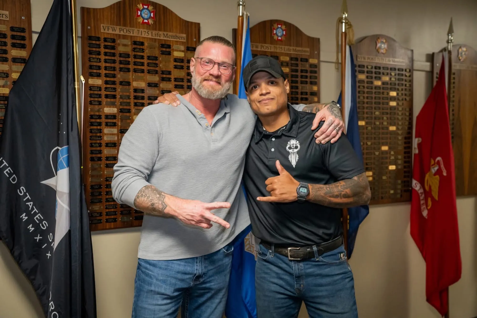 Josh and a friend in a memorial hall lined with plaques
