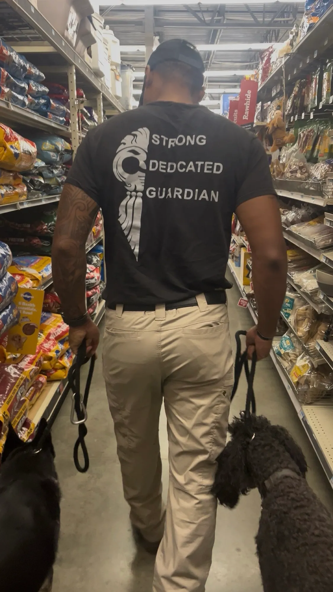 Josh walking two dogs on leash down a pet store aisle, practicing public access