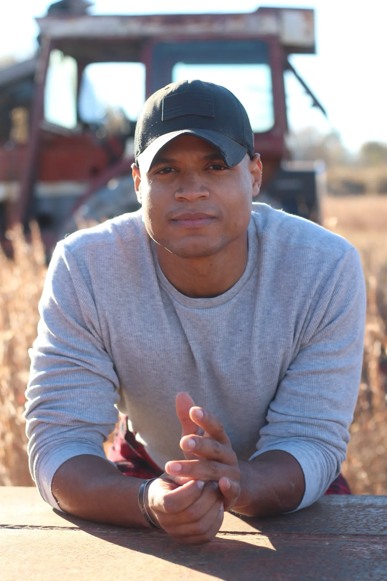 Josh, founder of Loyal Guardian Foundation, leaning on a weathered tailgate in a field